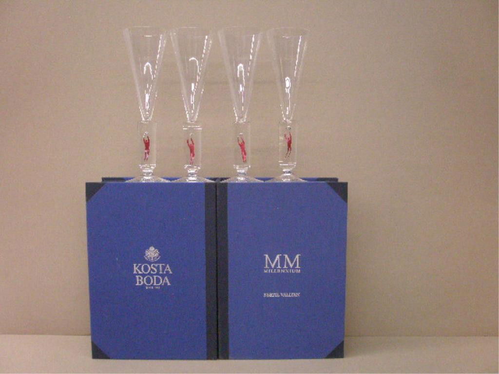 Kosta Bertil Vallien Millenium Flutes: Set of 4 Kosta Boda Bertil Vallien designed 2000 Millenium 10 1/4" champagne flutes, clear crystal with red foil leaping man inside of stem, with original boxes. Condition: Very good with no damage.