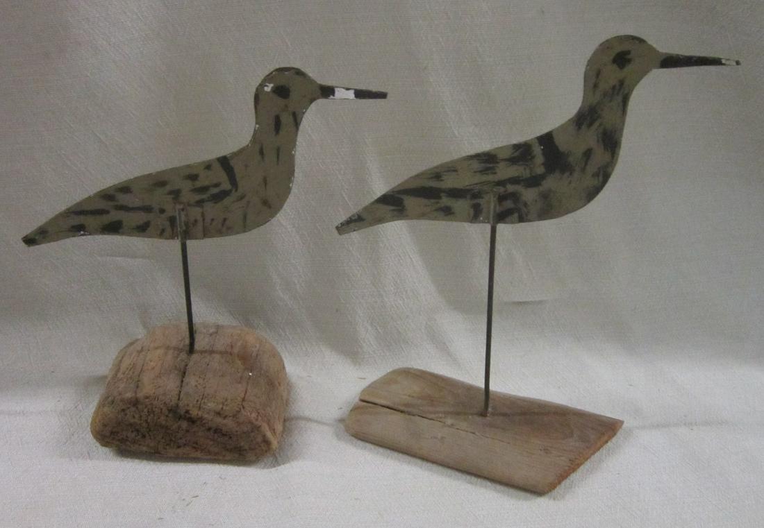 2 Tin Shore Birds: Two Tin Shore Birds, unsigned, painted sheet metal on metal rods, mounted into driftwood slabs; 7 1/2"h and 8 1/4", 7"l. CONDITION: Areas of paint loss, one bird pointed beak tip missing.