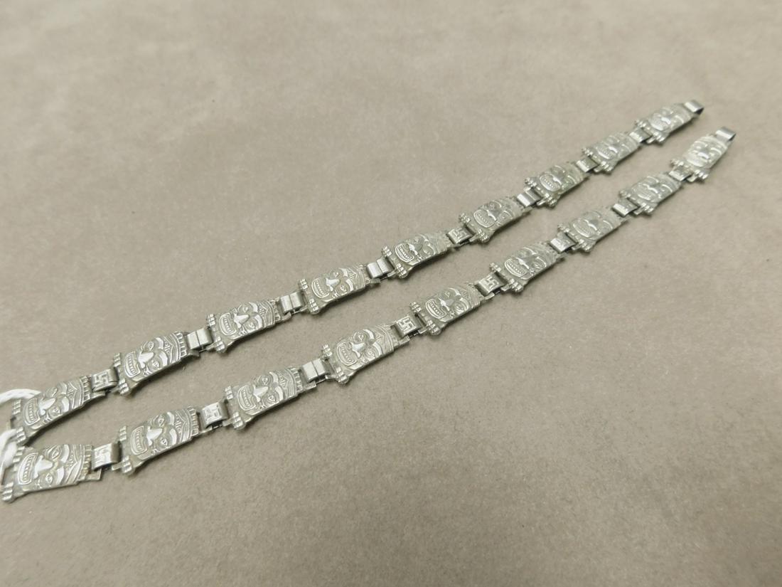 Pr. Sterling Tribal Mask Bracelets: Pr. Sterling Tribal Bracelets, 9 Native mask 7/8" links, hook and eye clasps, whirling log symbol on between links. 7 3/8" length, 3/8" width. 026 ozt. CONDITION: Very fine, vintage patina and wear.