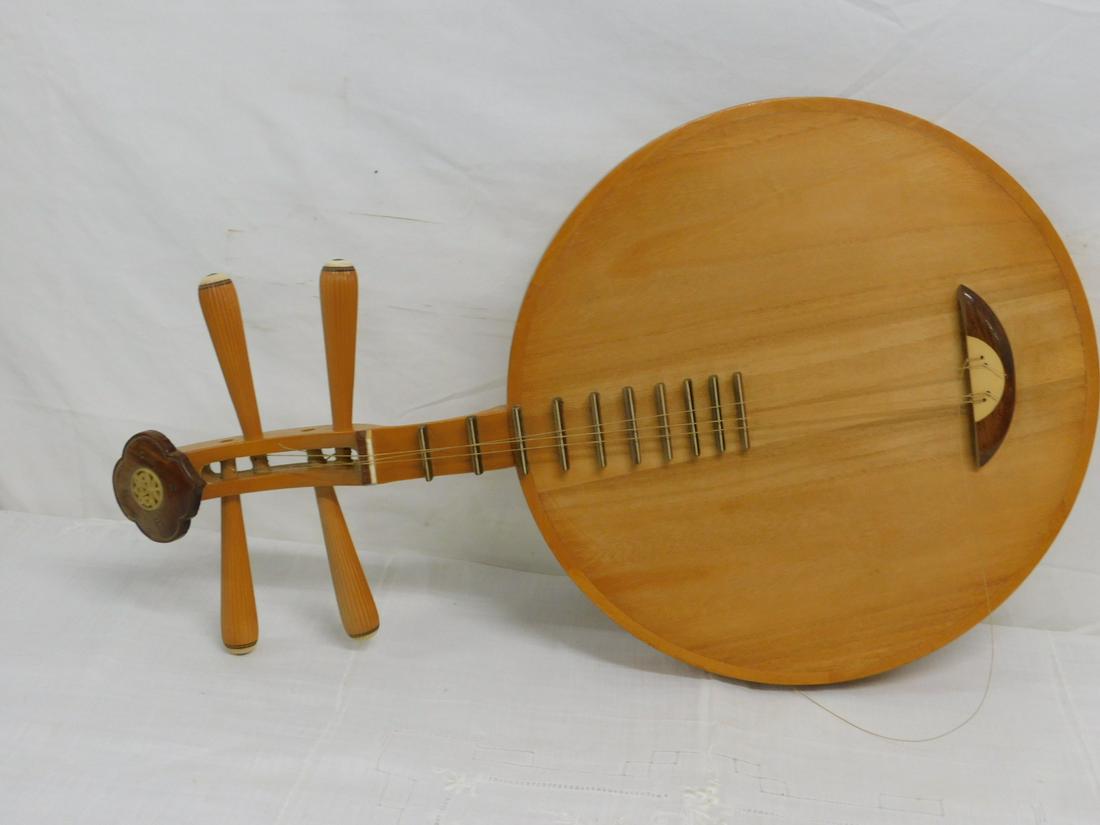 Chinese Yueqin String Instrument: Chinese Yueqin String Instrument, lute type in mixed woods, four strings, bone inlays, 20th C, 25"l, 14 5/8"d. CONDITION: Used cond, one string broken.