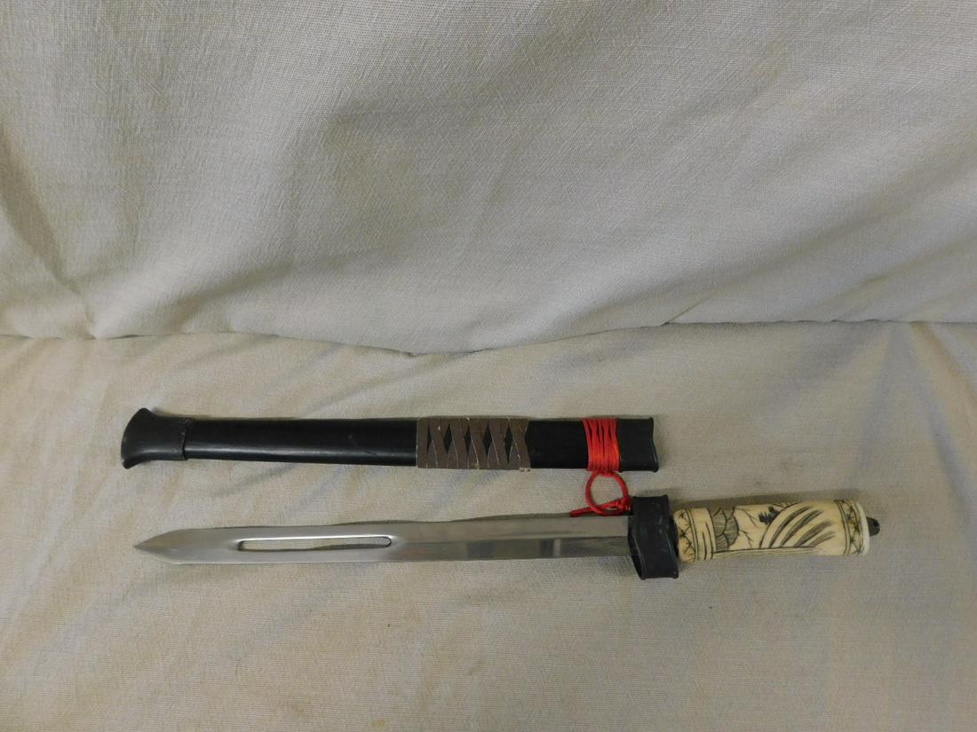 Chnese Dagger: Chinese dagger, engraved and inked bone handle with brass guard, open work 10 1/4" blade, wood and brass scabbard, overall length 16 1/2", late 20th c. CONDITION: Manufactured dull blades tarnished.