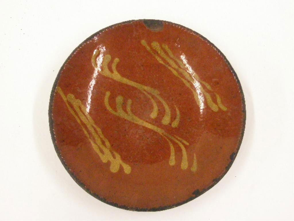 19th c. Redware Yellow Slip Decorated Plate: 19th c. Redware 8 1/2" plate with yellow slip wavy line decoration & coggled rim. CONDITION: Chips, wear & loss on rim, crazing & wear in center, heavy wear on back.