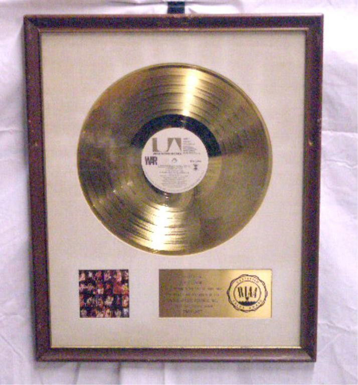War Gold LP Record Display: War "War Live" gold LP record display, set into a 16 1/2" x 20 1/2" frame, RIAA certified plaque, presented to Eddie Levine. Provenance: From the daughter of the late Eddie Levine, who had a distingui