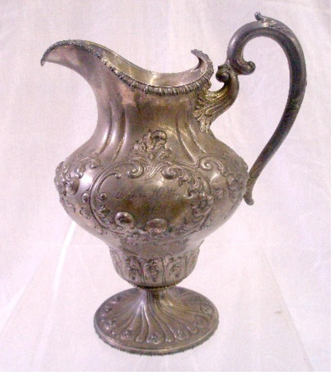 Theodore B. Starr Sterling Silver Pitcher: Theodore B. Starr sterling silver 10 1/2" water pitcher, with floral & scroll repousse, 22.15 troy ounces. CONDITION: Areas with wear, monogrammed & inscribed.