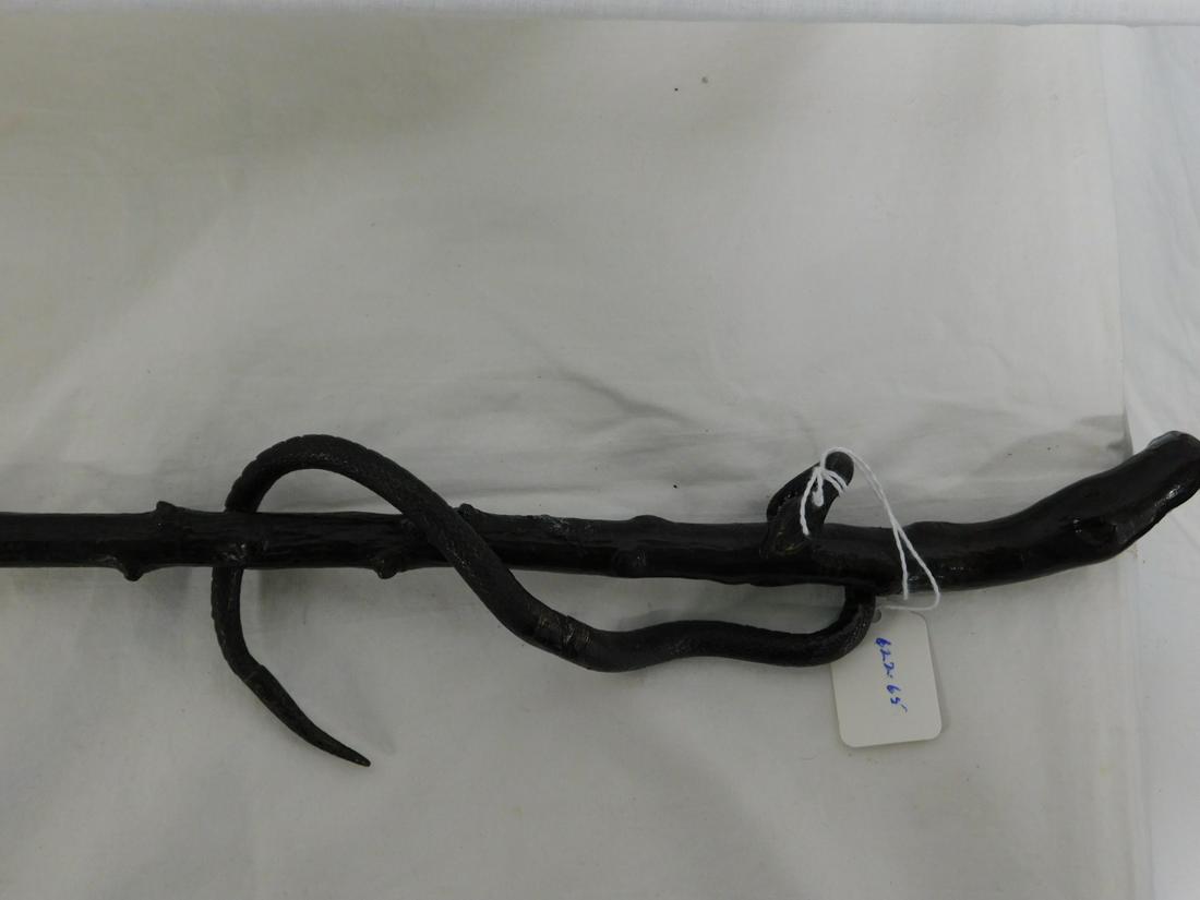 Circling Snake Cane: Circling Snake Cane. Handle: Sculpture cast bronze snake, approx. 6 1/2" long, wrapping around the shaft. Shaft: Knobbed natural wood branch. Ferrule: Steel. Length: 36 1/2". Vintage: Early 20th C. [6