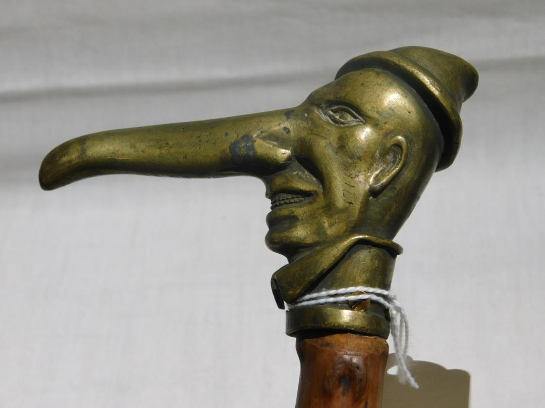 Anti Semitic Club Cane: Anti Semitic Club Cane. Handle: Brass cast head of man with long nose, open mouth with exposed teeth and wearing a cap, length 4 1/4". Shaft: Natural wood heavily knobbed. Ferrule: Steel and iron. Len