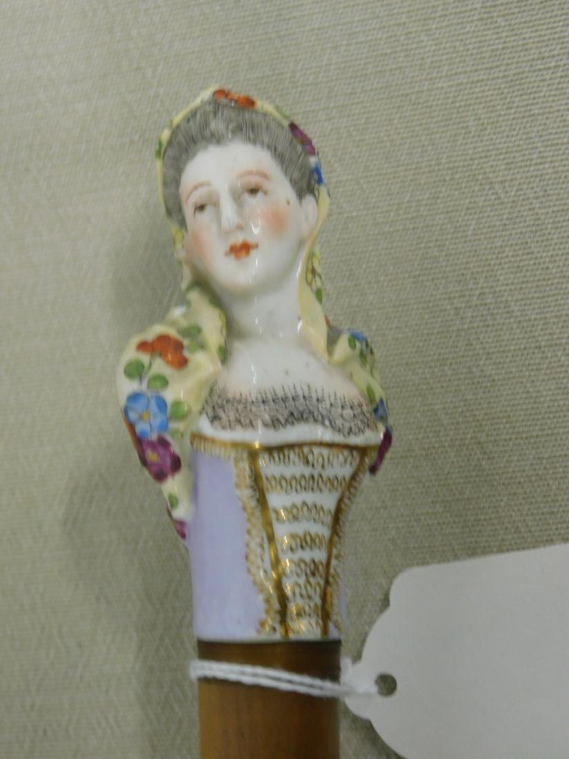 Female Bust Handle Parasol: Female bust handle parasol. Handle: possibly Meissen porcelain. Bust of Lady with underglaze floral painted shawl and lace painted bodice. (48) Collar: Copper band. Length: 30 1/2". Vintage: Late 19th