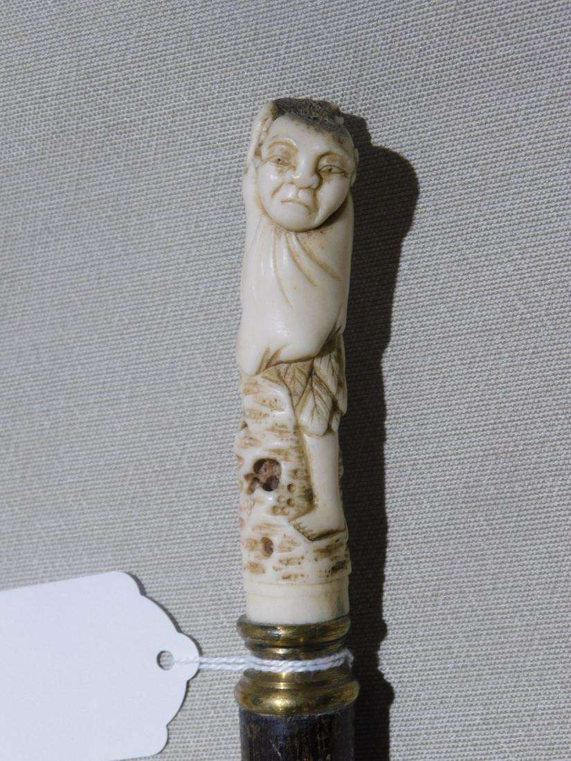 Japanese Figure Handle Cane: Japanese Figure Handle Cane. Handle: Bone carved standing workman holding a frog on his shoulder, 3 3/4"l. Collar: Brass. Shaft: Hardwood. Ferrule: None. Length: 38 1/2". Vintage: Early 20th C. [43] C