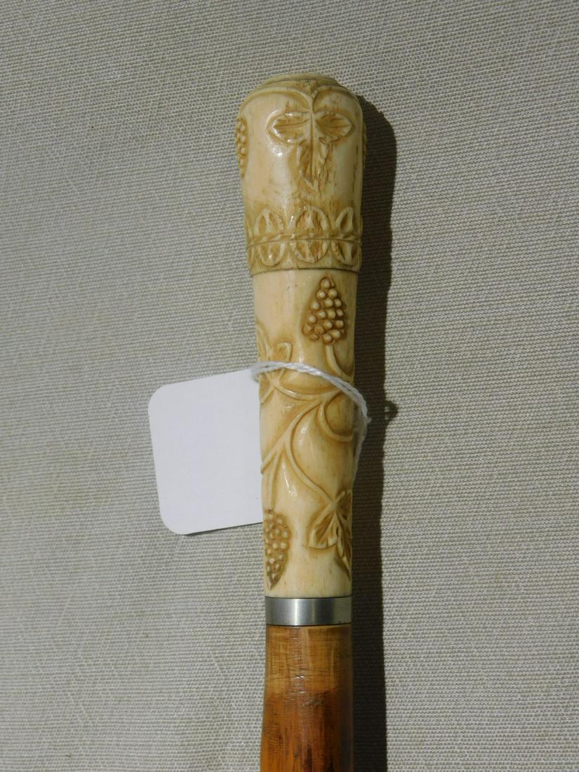 Grape Cluster Knob Cane: Grape Cluster Knob Cane. Handle: Bone relief carved grape clusters and leaves, 4 5/8"l, collar: nickle plated. Shaft: Natural knobbed wood. Ferrule: Brass. Length: 35 3/4". Vintage: early 20th C. [44]