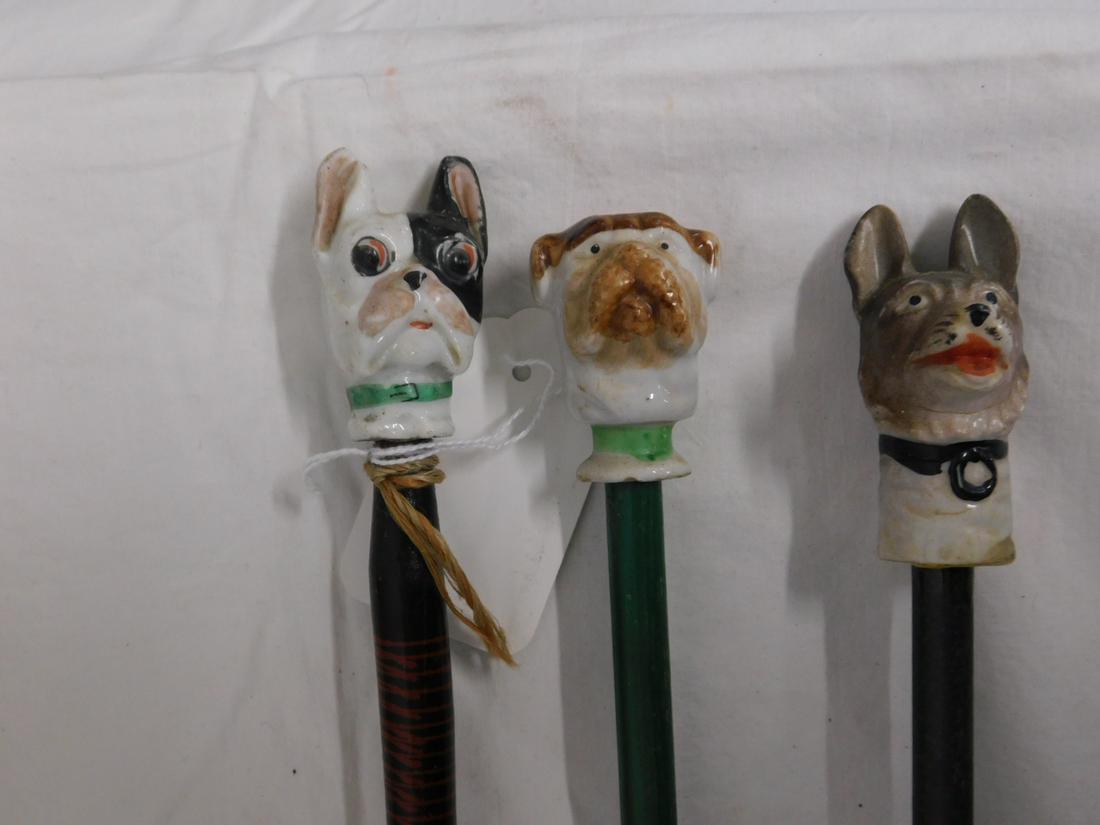 3 Dog Carnival Canes: Three Dog Carnival Canes, porcelain heads, one marked "Made in Japan", includes: two different bull dogs and one retriever, all on wood shafts, one with metal ferrule two 33 1/2"l, one 37"l. [82] COND