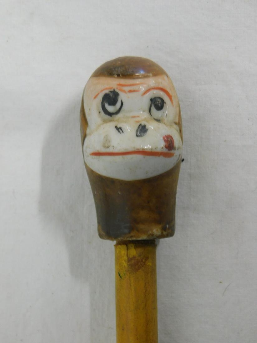 2 Monkey Carnival Canes: Two monkey canes, carnival type, painted porcelain includes: Full seated monkey with drum, and a monkey heads, painted dowel shafts, one with metal ferrule. 35"long, early to mid 20th c. [105] CONDITI