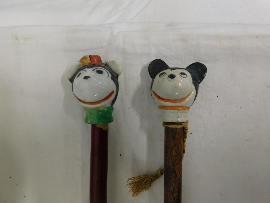 Minnie & Mickey Mouse Carnival Canes: Minnie and Mickey Mouse Carnival Canes: Painted porcelain handles, wood dowel shafts, Minnie with metal ferrule, 36"l, early 20th C. [79] CONDITION: Good, used, wear to shafts.