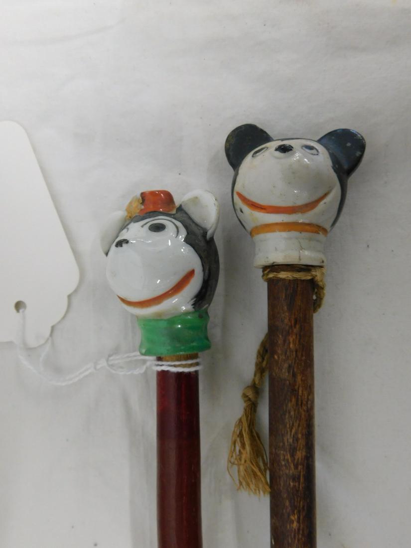 Mickey & Minnie Mouse Canes: Mickey and Minnie Mouse Canes, Carnival type, painted porcelain heads, "Japan", green and red wood dowel shafts, 34"l, early to mid 20th C.[100] CONDITION: Areas of paint wear on heads, small flake on
