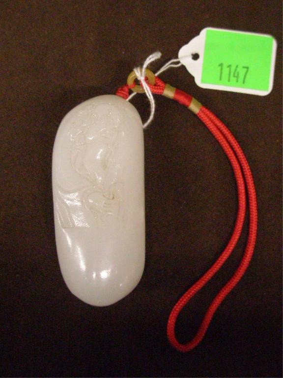 Chinese White Jade Pendant w/Relief Carved Man: Chinese white jade pendant with relief carved man w/long beard, 3 1/2" x 1 5/8", red rope strap attached with small jade ring, 20th C.