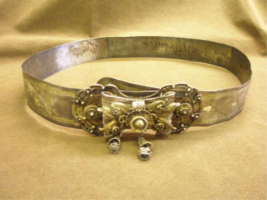 Antique Silver Crimean Belt: Antique silver Crimean belt, 1 3/8" wide band, overall gilted floral & 8 paint star motif chaising, flexes out to 34" length; filigree, wire & bead floral bow motif buckle 4" x 2", w/2 tassels, 1 miss