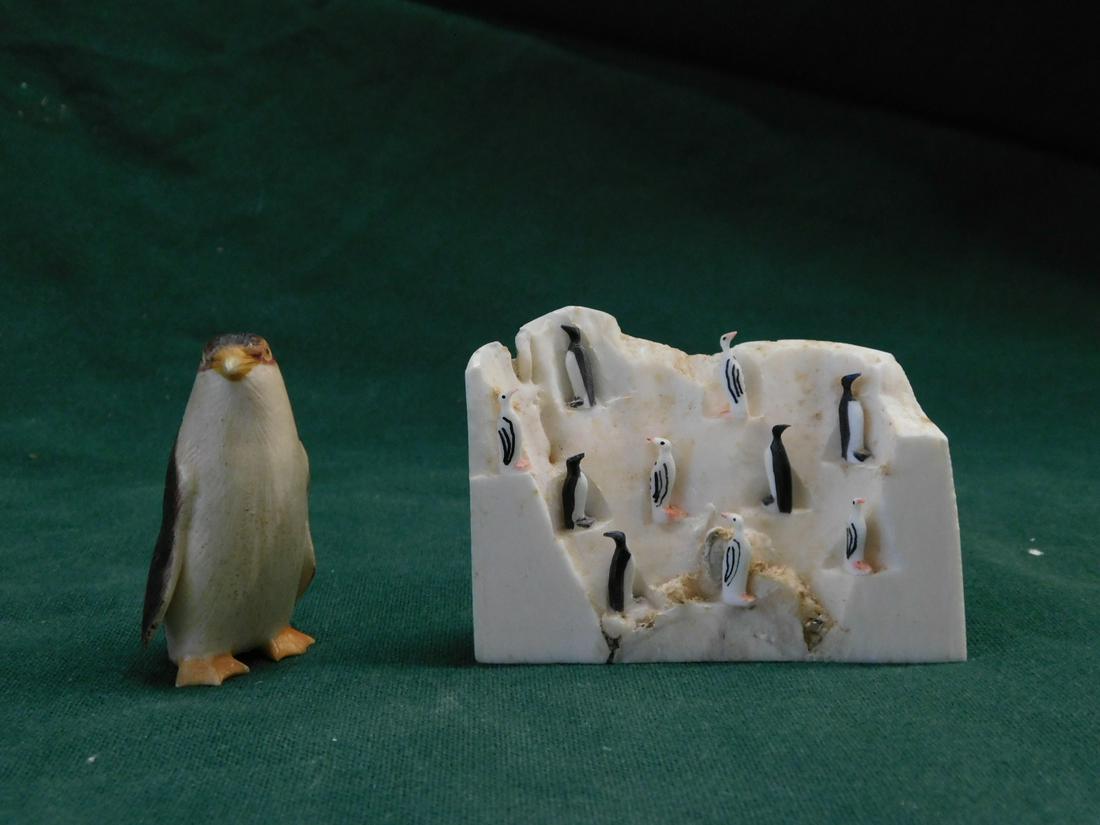 2 Penguin Carvings: Two Penguin Carvings, Raphael Nattanguk signed partial tooth with ten polychromed penguins, 2 3/4" x 2 3/4", and a carved and polychromed 2" standing penguin.[10a] CONDITION: Very good.