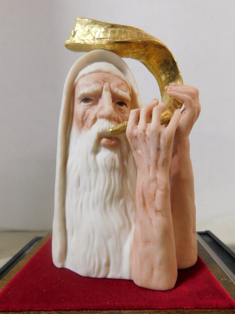 Ispanky Porcelain Judaica Figure: Ispanky Porcelain Judaica Figure, 5 5/8"h half bust of a Shofar blower, limited edition 18 /200, "18k solid gold parts", sets on a felt and wood base in a lucite case, 7 1/2" x 7 1/2" x 9". CONDITION: