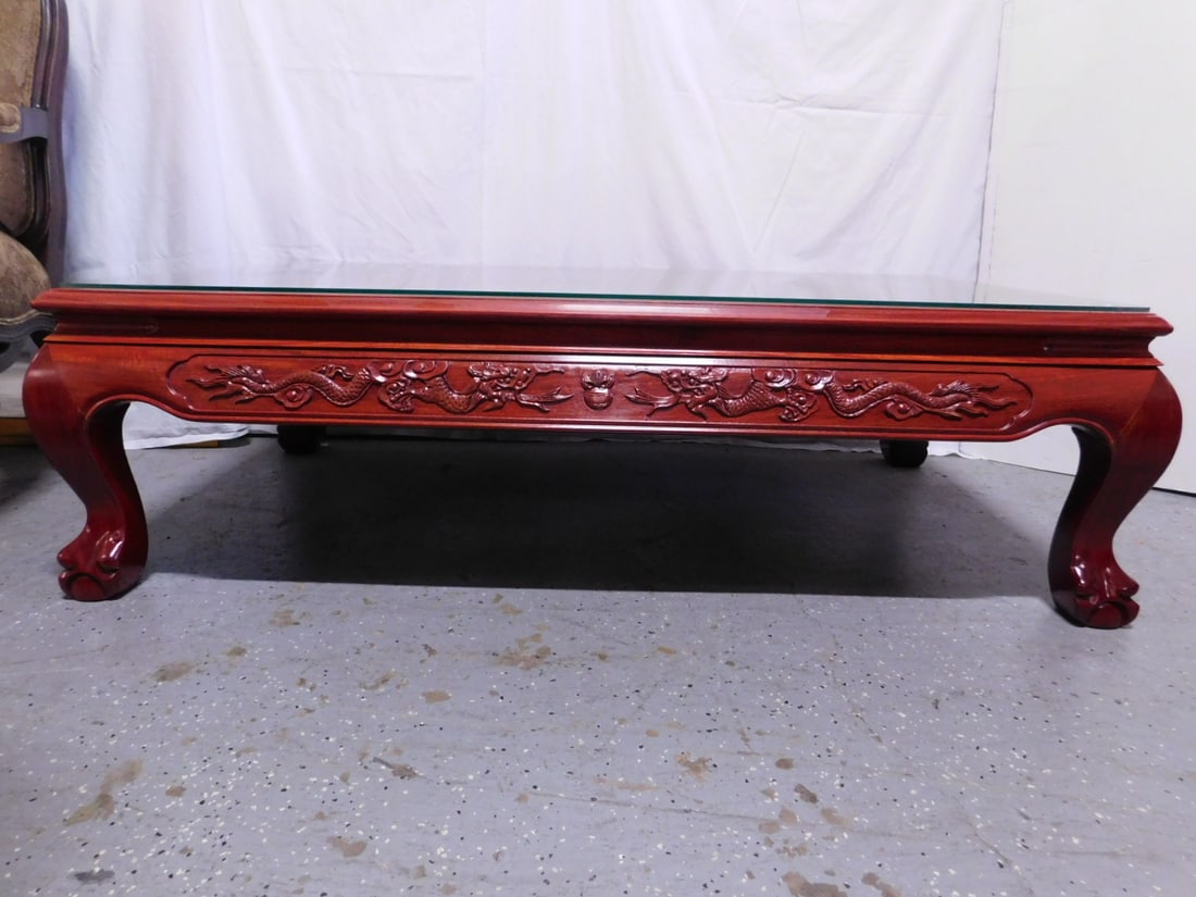 Chinese Coffee Table: Chinese Coffee Table, rosewood, dragon carved apron, cabriole legs with ball and claw feet, late 20th C, glass protective top, 31' x 56" x 16". CONDITION: A few areas of finish color change.