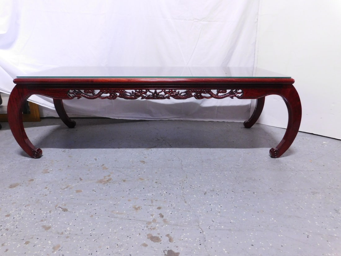 Chinese Coffee Table: Chinese Coffee Table, rosewood, dragon pierce carved apron, "C" scroll legs, late 20th C, glass protective top, 21 1/2" x 60" x 17". CONDITION: No issues identified.