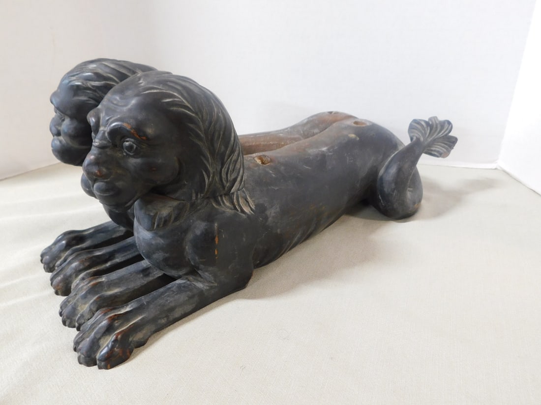 Pr Carved Lion Furniture Elements: Pair Carved Furniture Elements, mahogany hand carved reclining lions, one side of each is flat, 19th C, 18"l, 8"h. CONDITION: One missing tail, holes drilled into top of backs, exposed on neck.