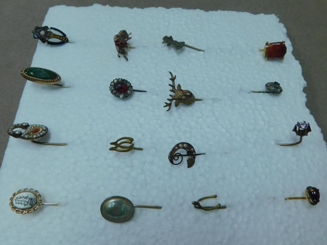 16 Vintage Stick Pins: 16 Vintage Stick Pins includes: amethyst, garnet, pearls, rhinestone, scrimshaw, buffalo, elk, wishbone and other forms. Early to mid 20th c. CONDITION: Used, finish wear, tarnished, 2 missing one see