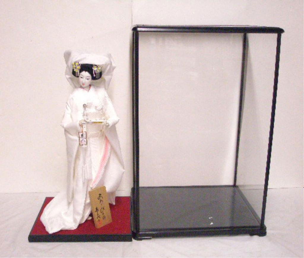 Contemporary Geisha Doll: Contemporary 20" Geisha doll with porcelain face, hands & feet together with plastic display case. Condition: Very good with no damage, case is missing back panel.