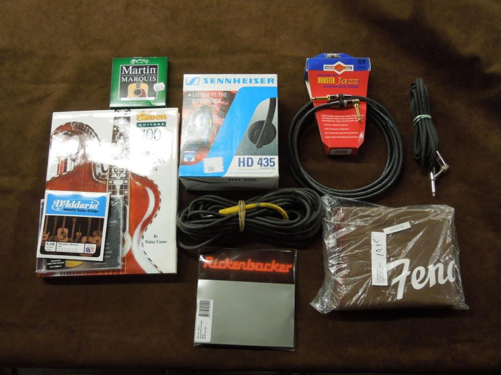 2 Lots of Instrument Cables: Two tray lots consisting of 3 instrument cables, Sennheiser HD-435 headphones, guitar & bass strings, Fender guitar bag & Gibson guitars 100 years of an American Icon book.
