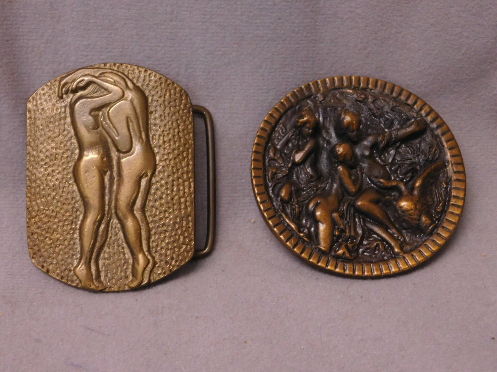 2 Vintage Nude Women Belt Buckles: Two Vintage Nude Women Belt Buckles, including: solid brass Taiwan 456 featuring, two kissing nude standing women 2" x 2 3/4", plus round Kalcaco Dallas 402 featuring nude women and swan, 2 7/8"d, bot