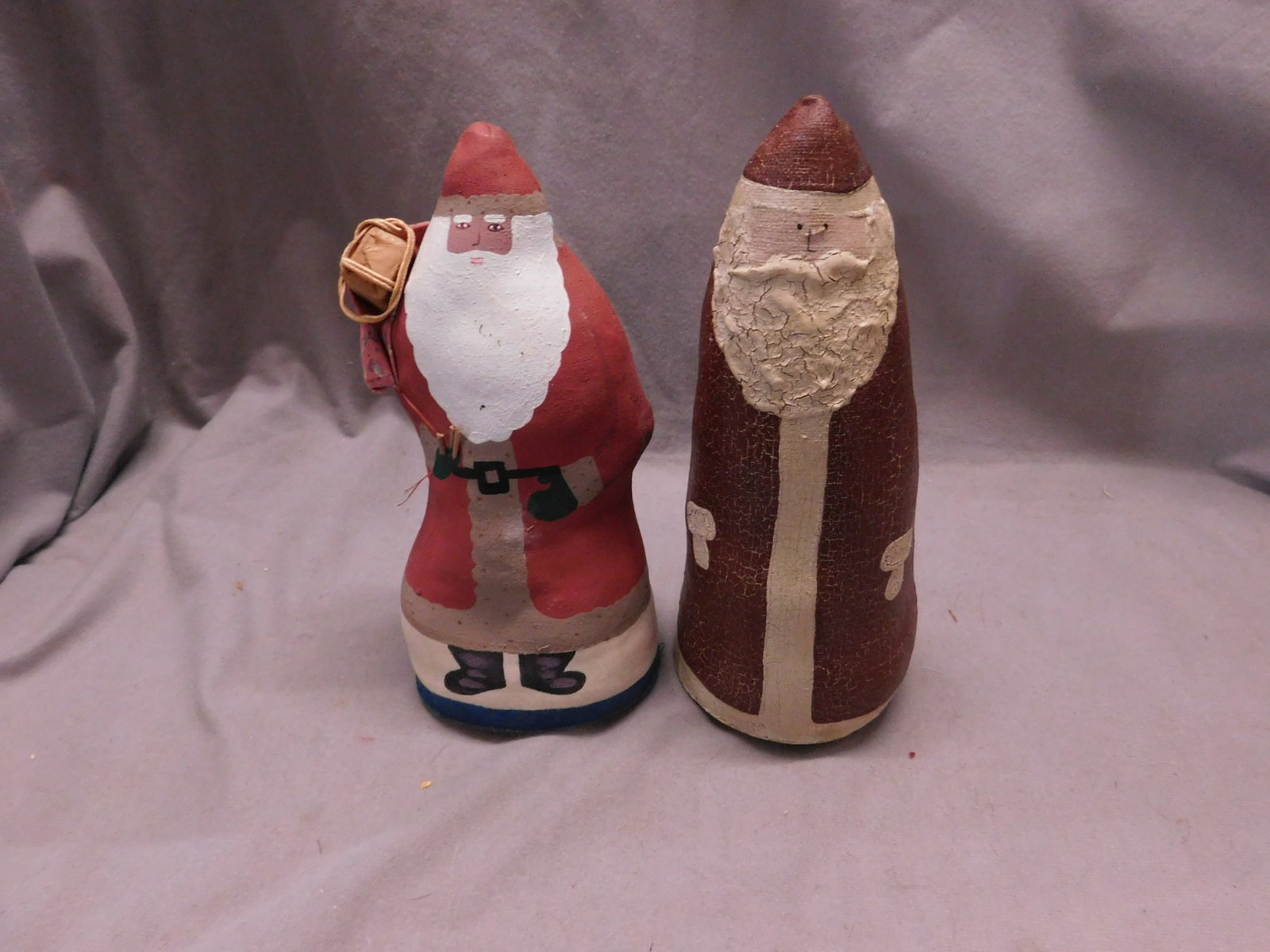 Vintage Haitian Fabric Santas: Vintage Haitian Fabric Santas, both hand painted, stuffed including: Santa holding toy sack (made in Haiti,taped on bottom), 7 3/4"h and one unmarked, 8"h. CONDITION: Unmarked Santa has paint crazing.