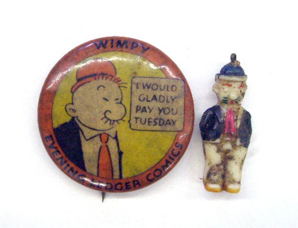 1930's Wimpy Pinback & Charm: 1930's Wimpy 1 1/4" Spencer & Co. "Evening Ledger Comics" celluloid with backpaper pinback & 1" plastic Cracker Jack charm. CONDITION: Both have wear.