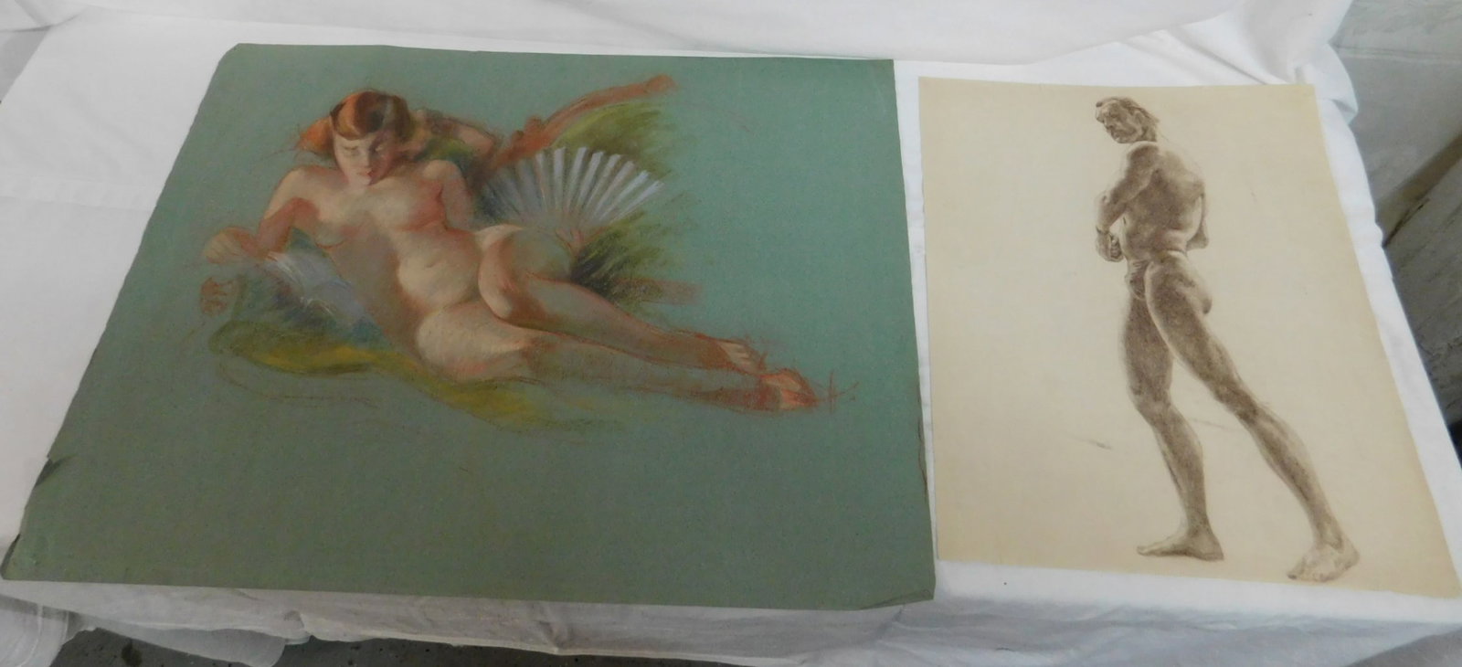 2 Nude Drawings: Two Nude Drawings, unsigned, includes: pastel on green paper, reclining female nude with fan, early 20th C, paper size 19" x 25", and a burnt umber drawing of a standing muscular male nude. CONDITION: