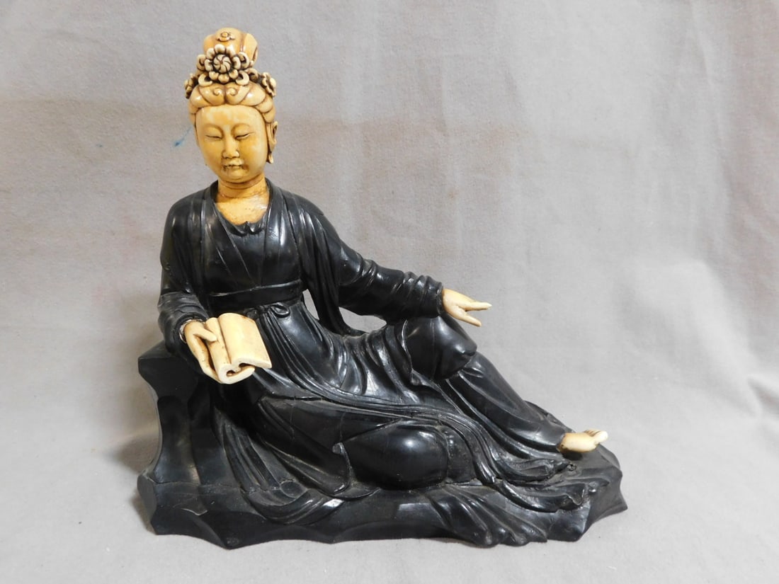 Antique Chinese Carved Figure: Antique Chinese Carved Figure, ebony carving of a seated Quan Yin with bone carved head, hands, book and foot, 19th C, 9 1/2"l, 8 /2"h. CONDITION: A few small expansion splits; one hand missing two fi