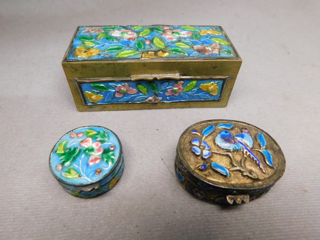3 Chinese Enameled Boxes: Three Chinese Enameled Boxes, silver finish and brass; all relief or puffy molded, includes: 1 3/4" x 1 5/8" oval pill ob with birds and flowers, 1 1/8"d round floral pill box; and a 3 3/8" x 1 1/2" x