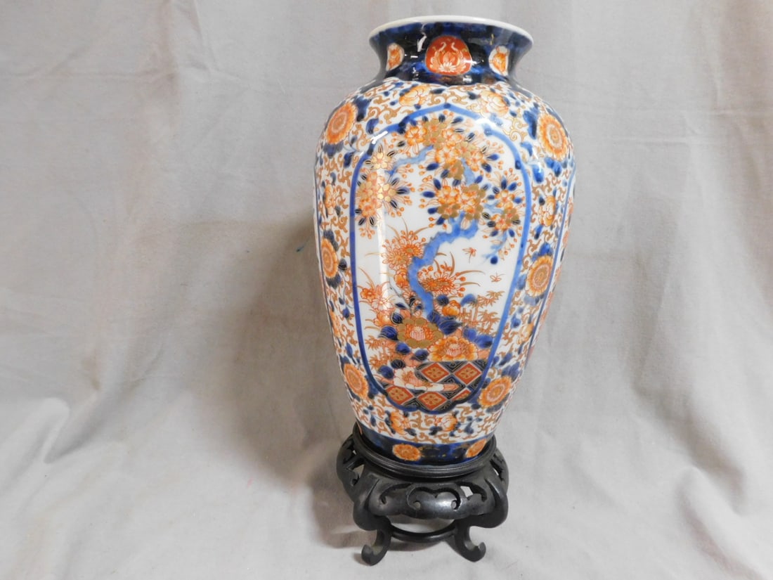 Japanese Imari Vase: Japanese Imari Vase, 19th C, baluster form with reverted rim and typical Imari colors in the alternating floral and foliate panels, red markings on base, 10 1/4"h, includes: carved wood footed stand. 
