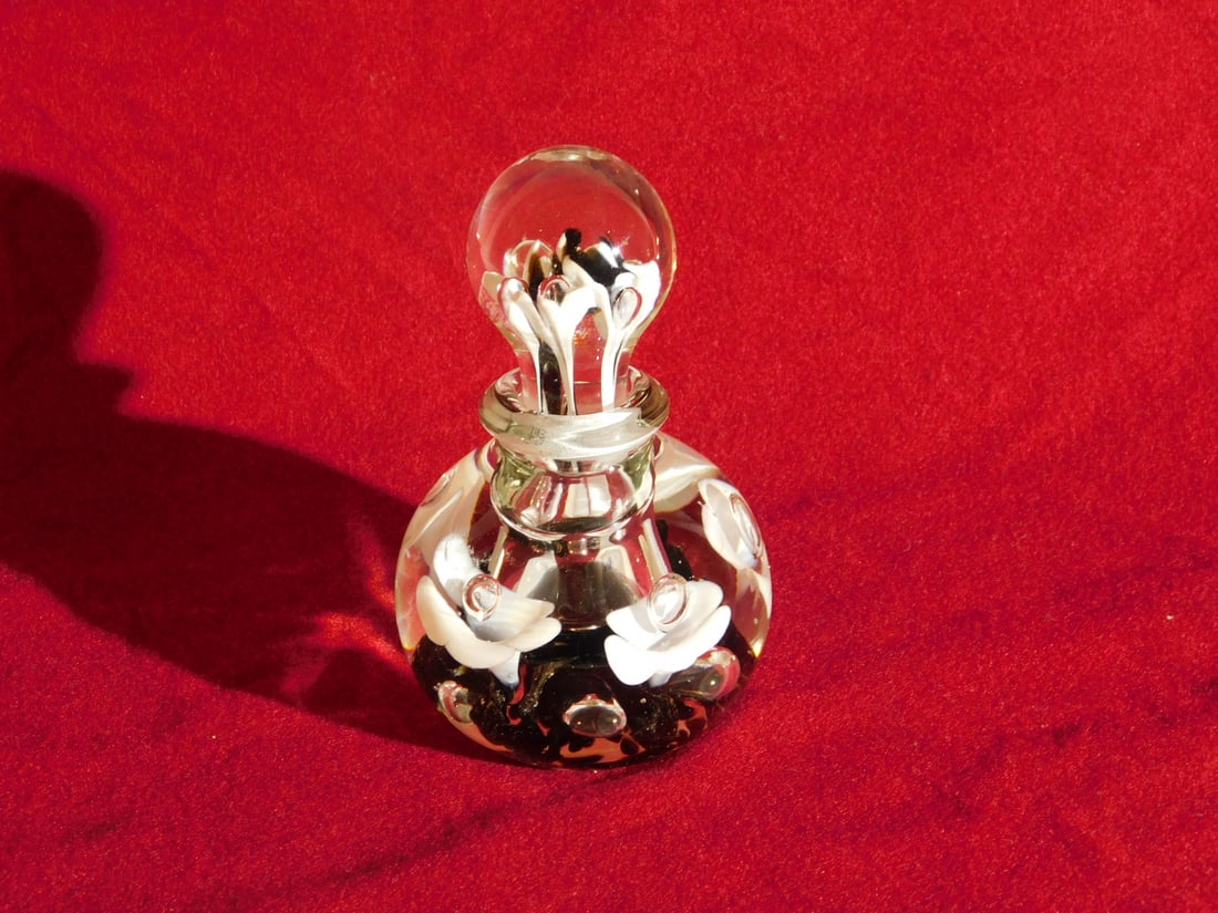 St. Clair Paperweight Perfume: St. Clair Paperweight Perfume, clear crystal with black and white floral interior, 20th C, 5 1/2"h. CONDITION: Very fine.
