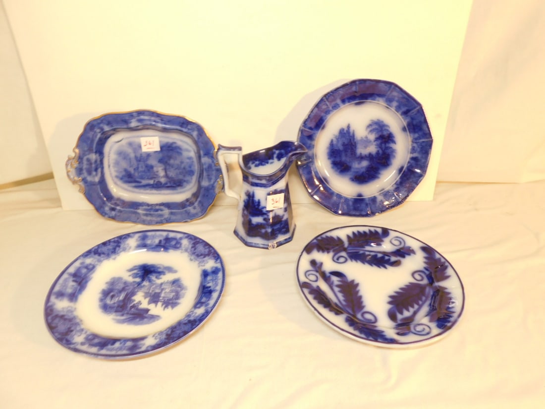 5 Flow Blue Pieces: Five Flow Blue Pieces, includes: English Oriental pattern footed open vegetable 11"l, two 10" plates and a 7" creamer, and a foliate pattern 9 1/2" plate. CONDITION: One plate with small edge chip, cr