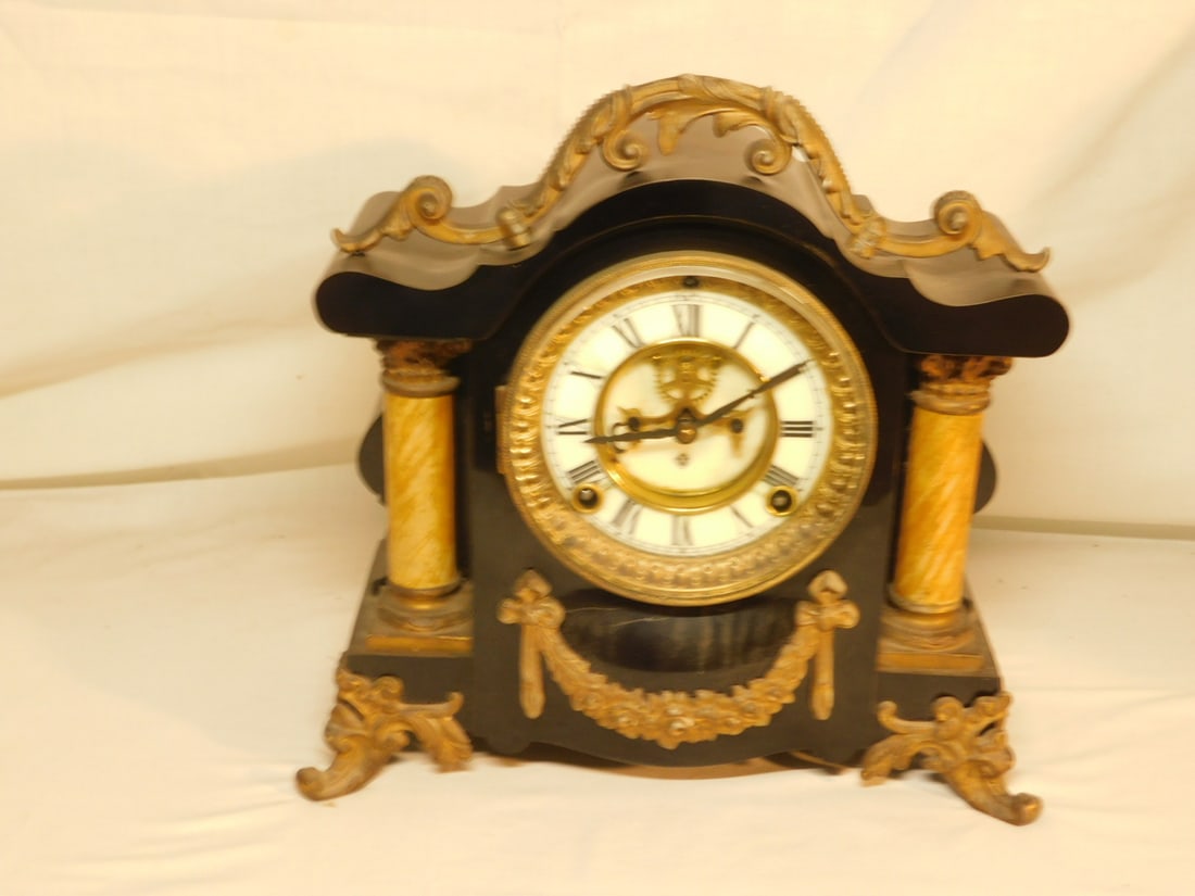 Ansonia Mantel Clock: Ansonia Mantel Clock, black enameled iron with brass finished scroll work mounts and feet, porcelain dial with open escapement, time and strike movement, late 19th c. 11" x 10 1/2" x 5". CONDITION: So