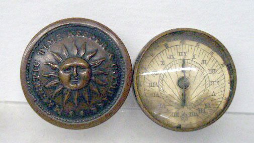 D.L. Smith's Time Keeper and Compass: 19th c. D.L. Smith's magnetic time keeper and compass, encased in a 3/4" x 1 3/4" round brass box containing a combination sundial/compass, embossed sun on lid, marked on base "D.L. Smith's Patent Aug