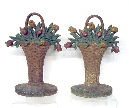 Hubley Cast Iron Tulip Basket Doorstops: Pair of Hubley Mfg. Co. painted cast iron #86 Tulip Basket 13 1/8" x 9" doorstops. CONDITION: Both have areas with wear, rust & paint loss, 1 has portion of leaf missing. Provenance: Estate of Winifre