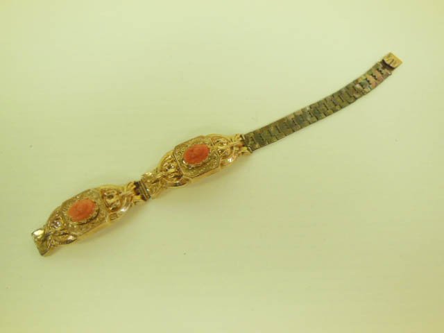 Victorian Gold & Coral Bracelet: Victorian gold and coral bracelet, tested 14k two arched engraved and stamped scroll bar mountings, each support a small carved coral cameo flexible link book chain with "V" spring closure. 6" length,
