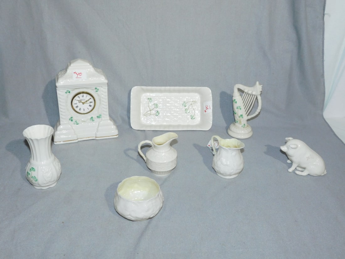 8 Pcs Belleek Porcelain: Eight Pieces Belleek Porcelain, includes: 7 3/4"h, clock, brown mark 6" harp, two green mark creamer and one sugar, an unmarked 8 1/2" x 4 3/4" dish, brown mark pig and a black mark 4 3/4" vase. CONDI