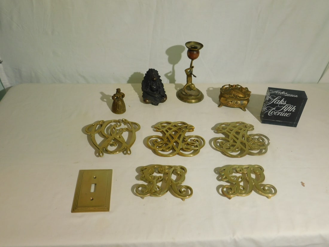 Brass Lot Trivets, Etc.: Brass Lot, includes: five Williamsburg trivets, 7" monkey brass and wood candlestick, figural bell, bronze plated metal Indian Chief incense cover; bronze plated Nouveau style jewel box, etc. CONDITIO
