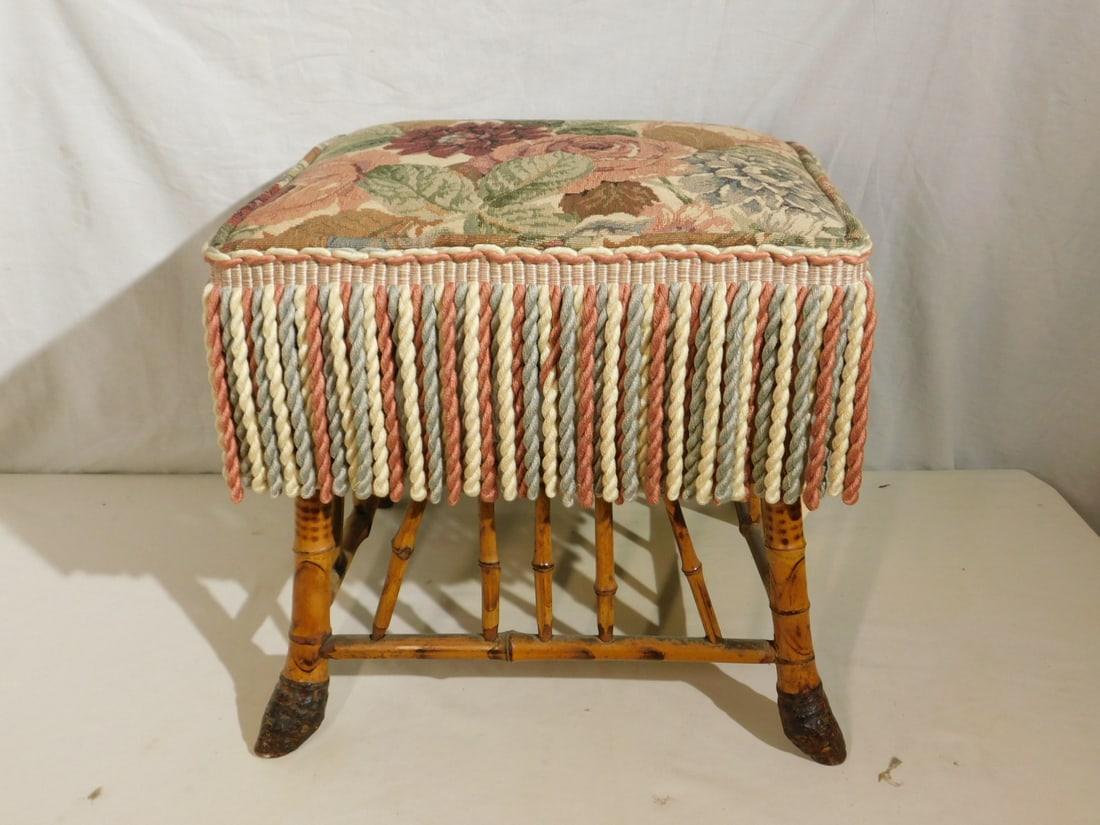 Bamboo Ottoman: Bamboo Ottoman, splayed bamboo legs with spindle stretchers, floral tapestry type upholstery with long fringe, late 19th C, 16" x 14" x 14". CONDITION: Stretchers separating from legs.