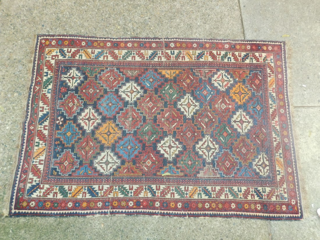 Antique Caucasian Throw Rug: Antique Caucasian Throw Rug multi color geometric medallion and a cream and red border, early 20th C, 60" x 41". CONDITION: Areas of wear.