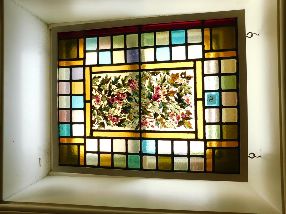 Victorian Stained Glass Window: Victorian Stained Glass Window, a multi color block pattern leaded glass surrounds a floral painted center panel, late 19th C, 24 1/2" x 20". CONDITION: Two blocks with cracks.