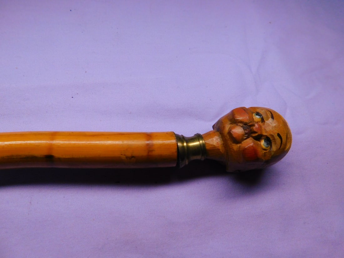 Cork Screw Head Cane: Cork Screw Head Cane, knob top carved and polychromed bald man's head, unscrews to a wine cork screw, brass bezel, bamboo shaft, metal ferrule, mid 20th c, 36"l.[2] CONDITION: Very good.
