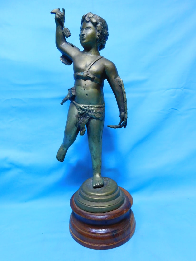 Bronze Cupid Sculpture: Bronze Cupid Sculpture, unsigned, standing cupid with bow and arrow quiver, wood base, 20th C, 15 1/2"h. CONDITION: Tarnished.