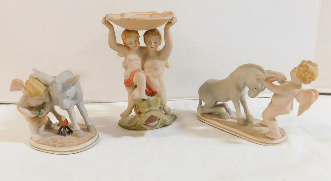 3 Albert Angel Groups: Three Albert Angel Groups, painted bisque, two marked occupied Japan, two with donkies and one with dolphin, from 4" to 6"h. CONDITION: One with broken and glued donkey ear.