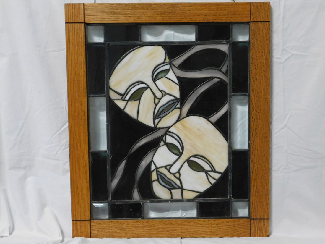 Stained Glass Window: Stained Glass Window, smoked, carmel and beveled clear glass, depicts to masks, oak frame, late 20th C, 25" x 21 1/2". CONDITION: One ribbon with crack.