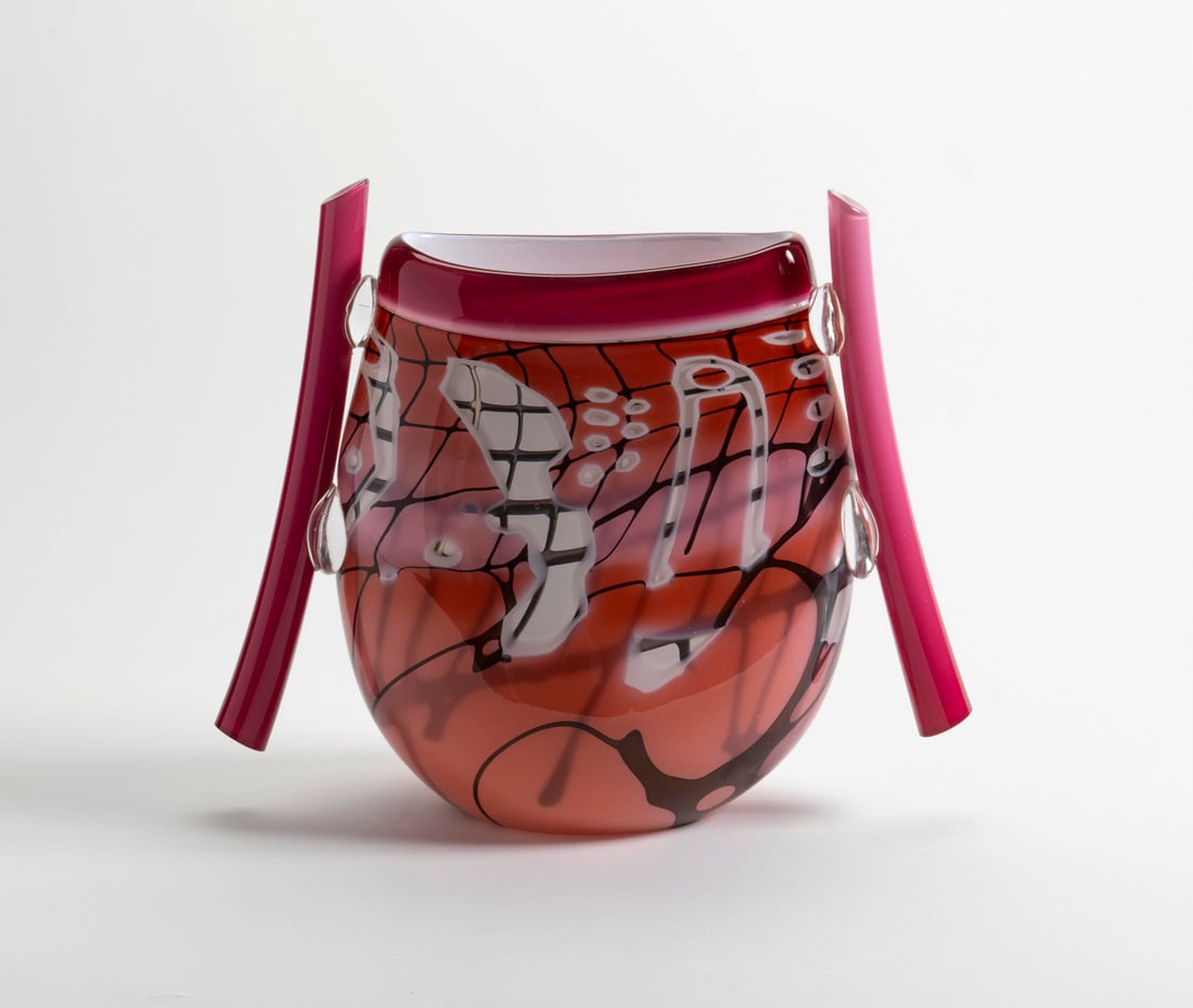 Janice Enns & John Leighton - Urn: Janice Enns and John Leighton - Urn, signed on base, '97, peach to cranberry cased glass with black and white abstract designs and two cranberry cased glass tubular handles, 14" x 14" x 4". CONDITION: